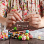 Relax hobby. Female make craft beads at home